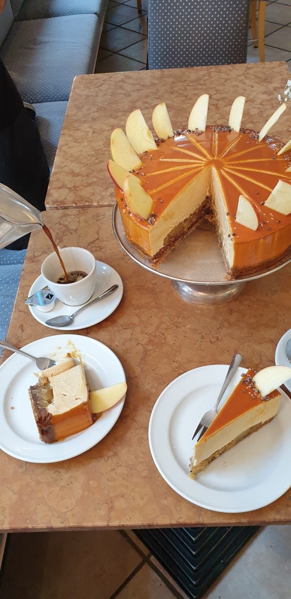 Angeschnittene Torte mit Kaffee am Tisch