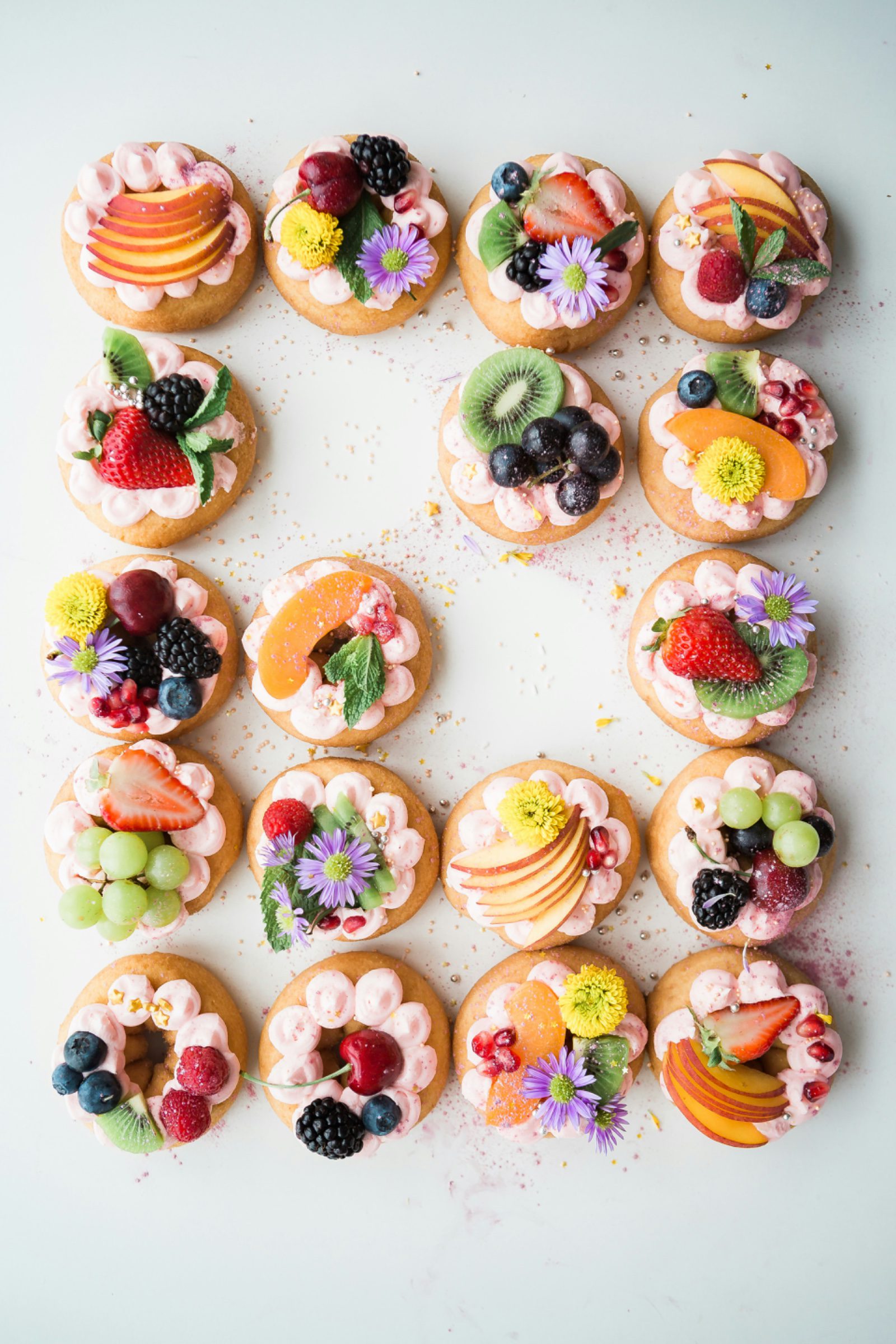 Bunte Obsttörtchen mit frischen Früchten und Blüten
